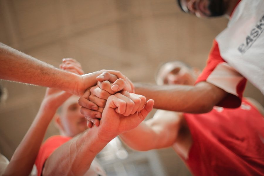 Group of sports players bumping fists.