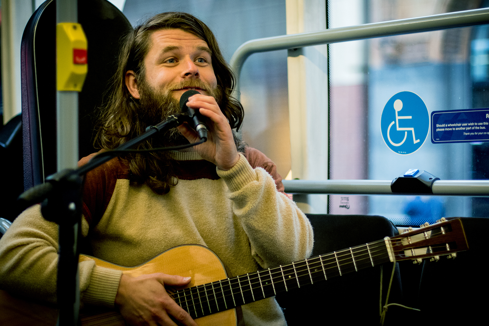 A guitarist plays music on a bus