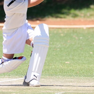 Closeup of a cricket player hitting a ball