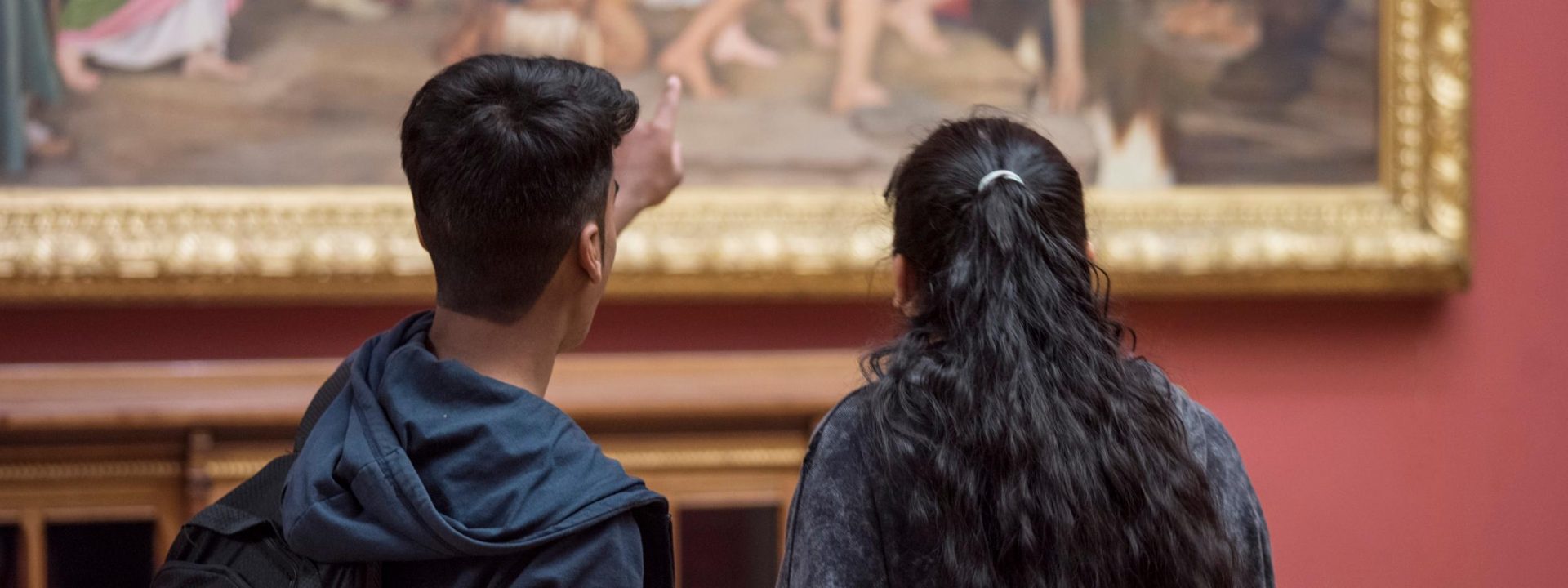 Woman and a man looking at a painting.
