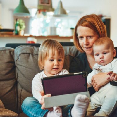 A mother on a sofa with two children and a tablet