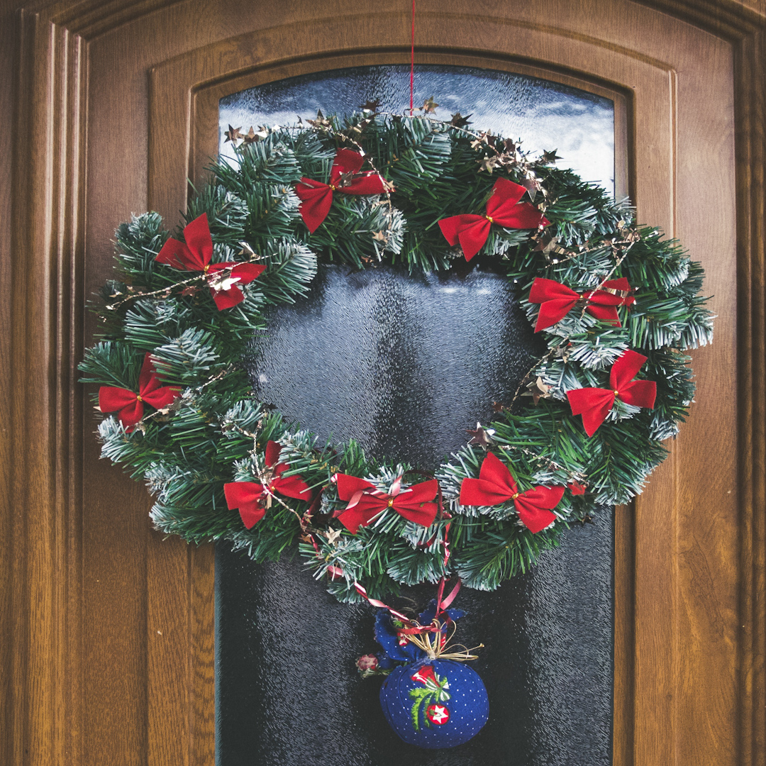 A Christmas wreath hanging on a front door.