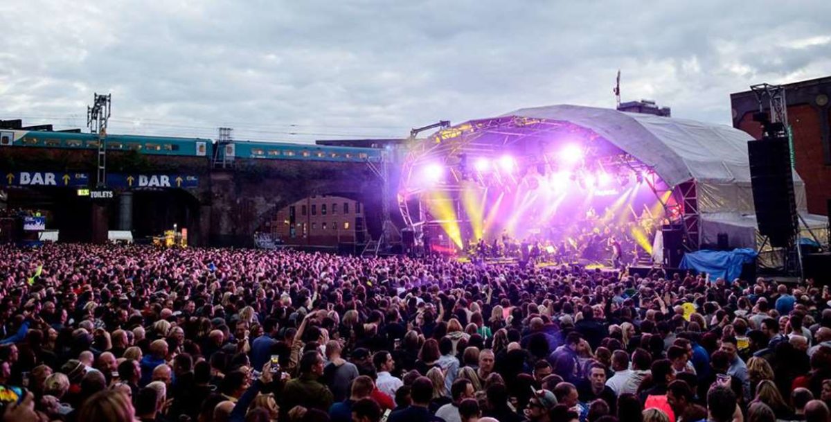 Crowds gather to enjoy themselves at a music concert in Castlefield Bowl.