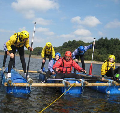 A group of young people sailing on a raft.