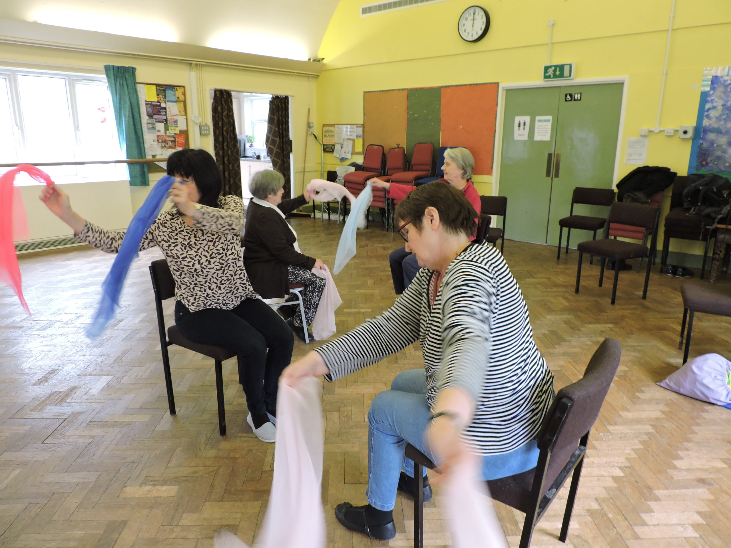 A group of people enjoy a chair dancing session.