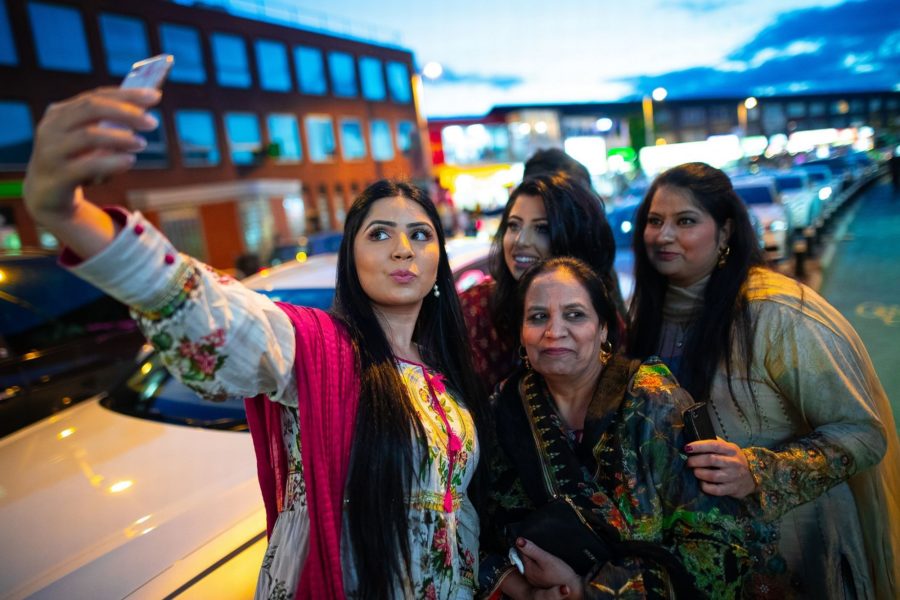 A group of four women taking a selfie on the Curry Mile in Rusholme.
