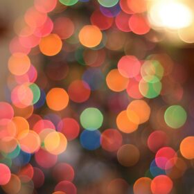 An up close image of the colourful lights on a Christmas tree.