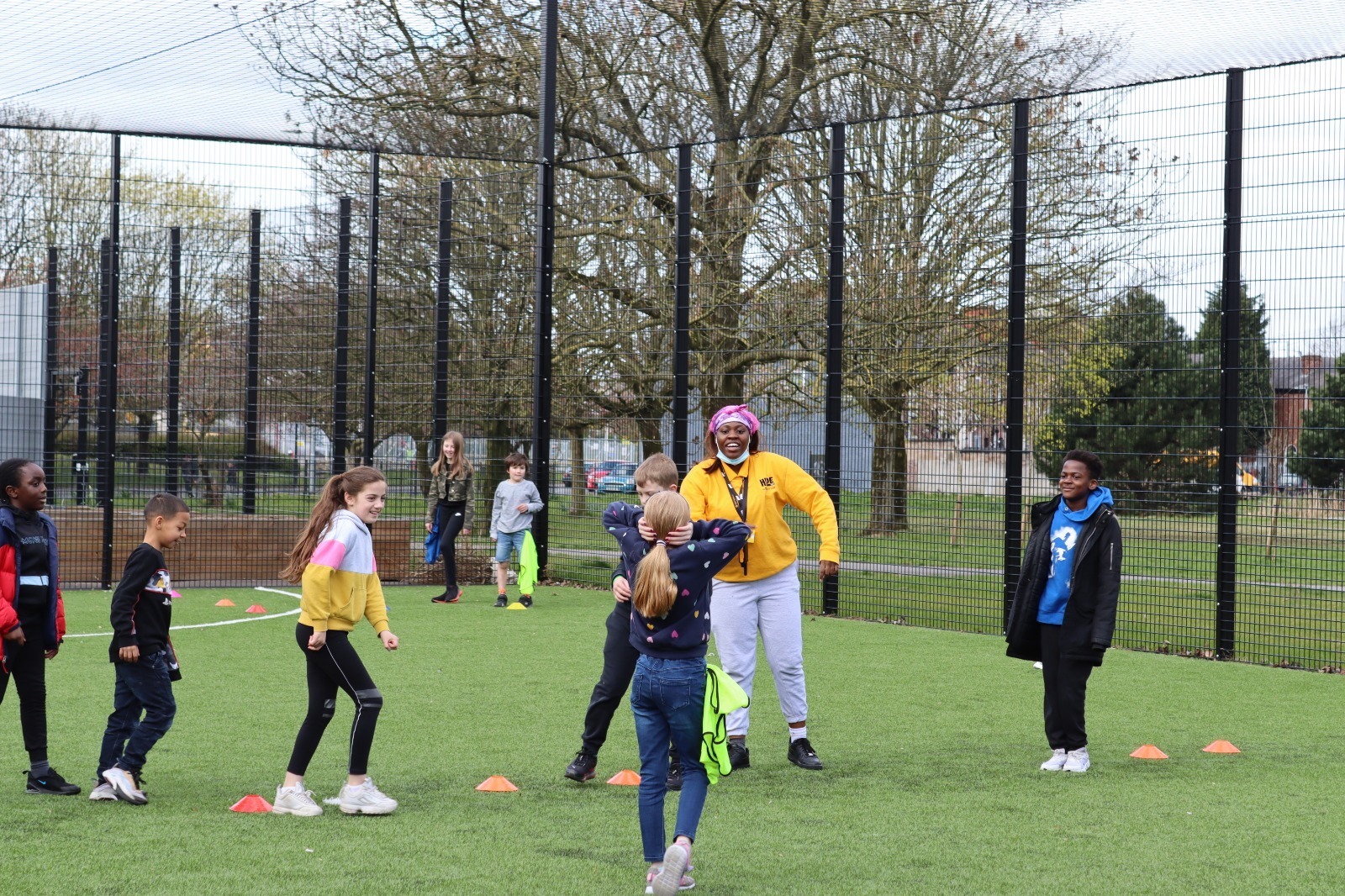A group of young people enjoy a multi-sports session outdoors.