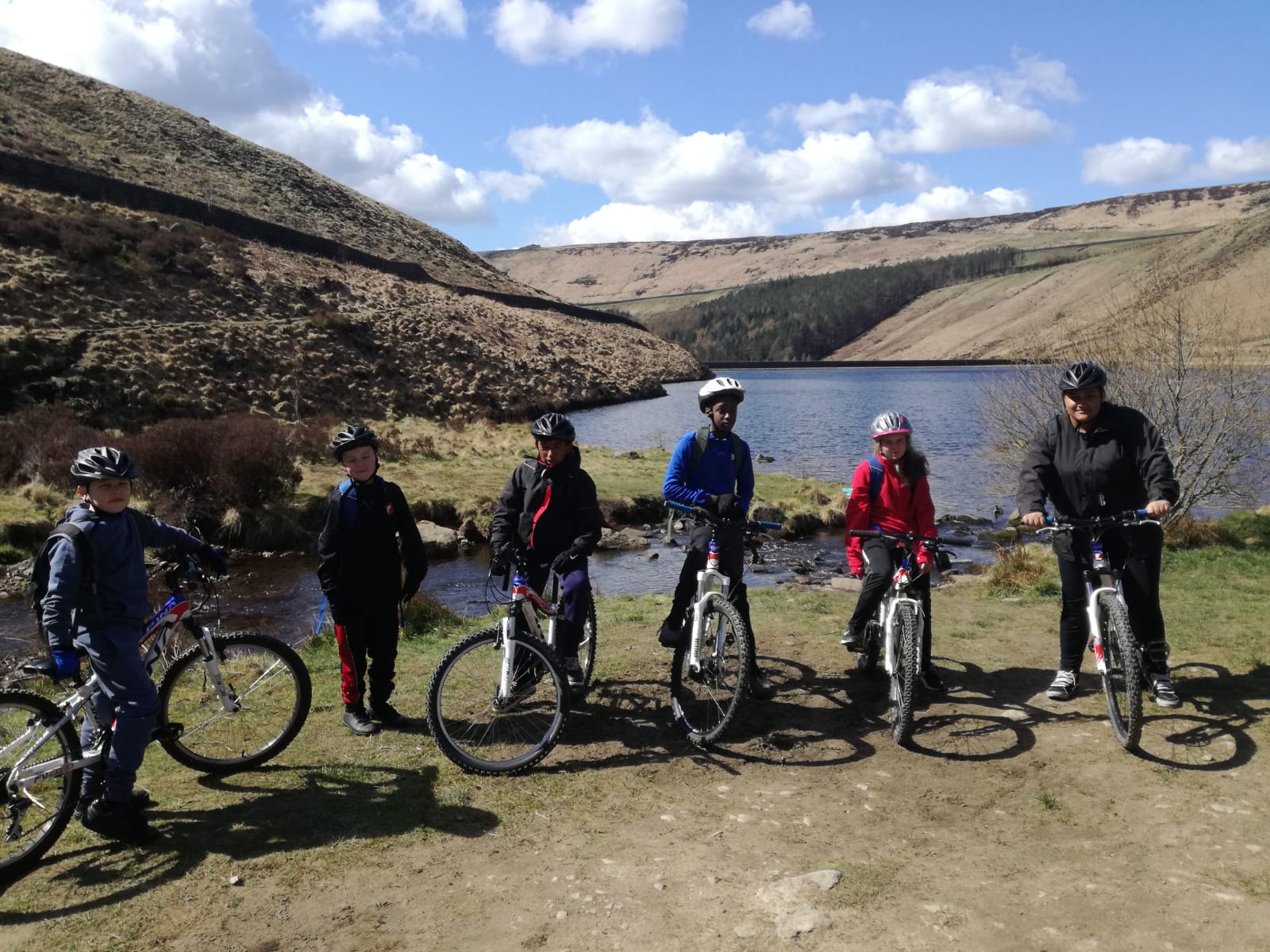 A group of young people get ready to set off on a mountain bike ride.