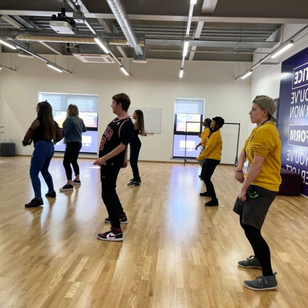 A group of young people enjoy a dance session in a studio.