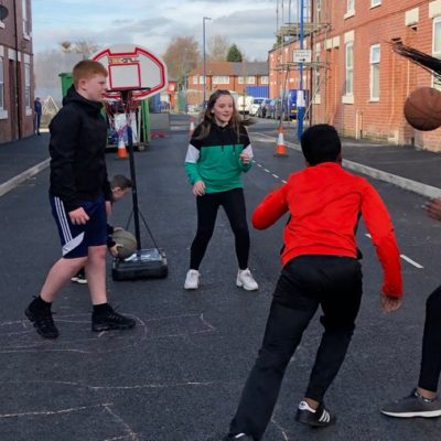 Youngsters playing sports together on Bakewell Street in Gorton, Manchester.