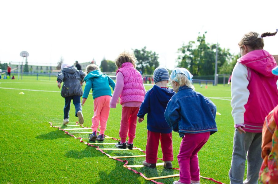 A group of children enjoy playing a game outside.
