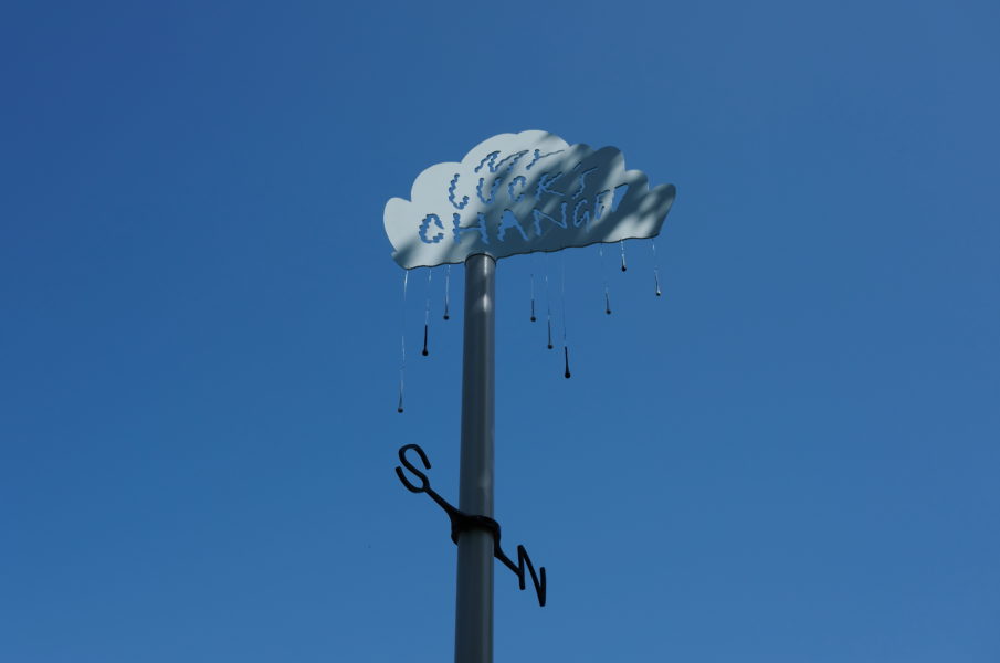 A weather vane sits against a blue sky.