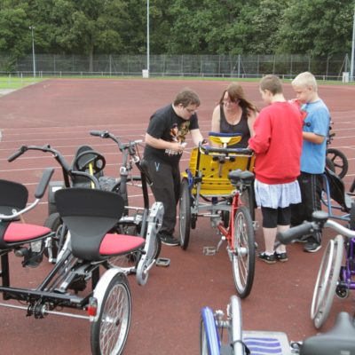 A group of cyclists get ready to ride in tandem on an adaptive bike.