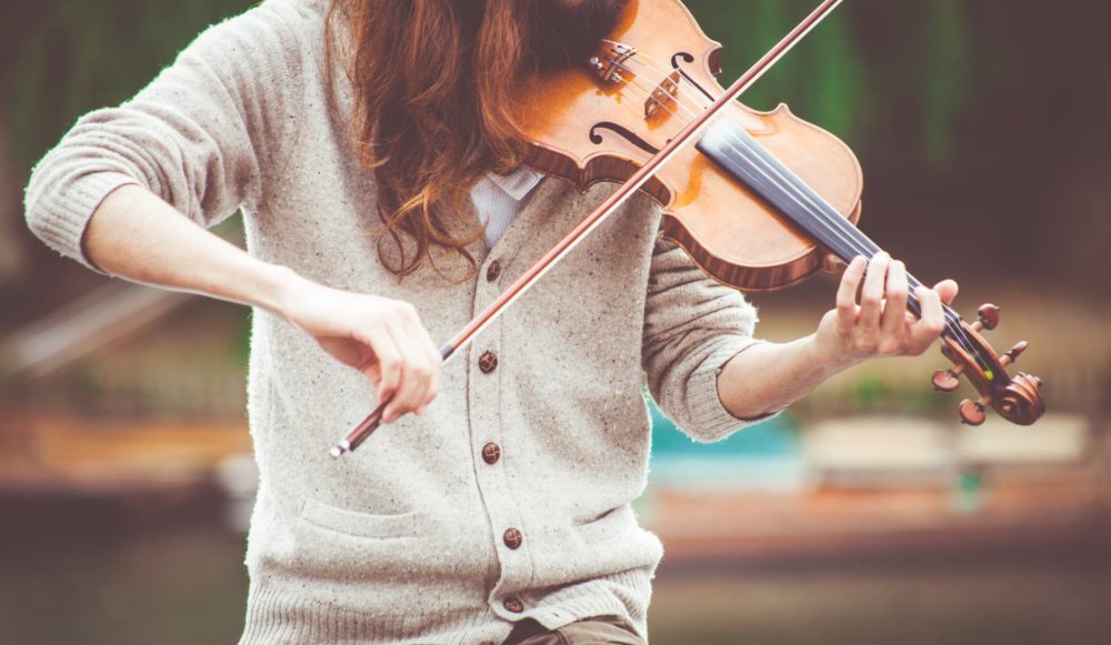 A young person plays a violin.