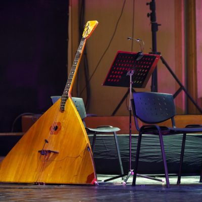 A balalaika (a Russian stringed musical instrument) sits on a stage.