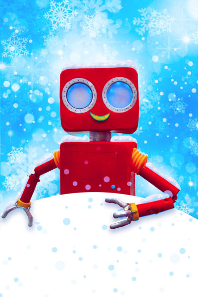 A red robot stands in the snow set against a blue sky.