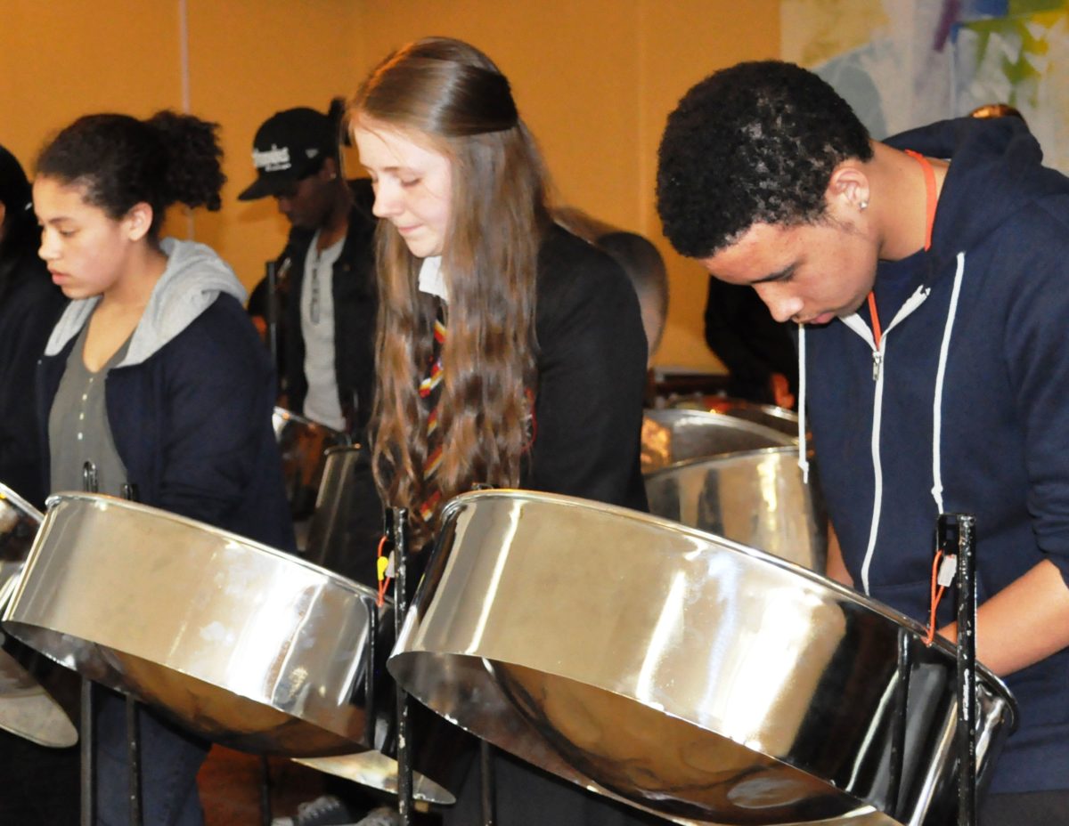 A group of young people playing the steelpans together.