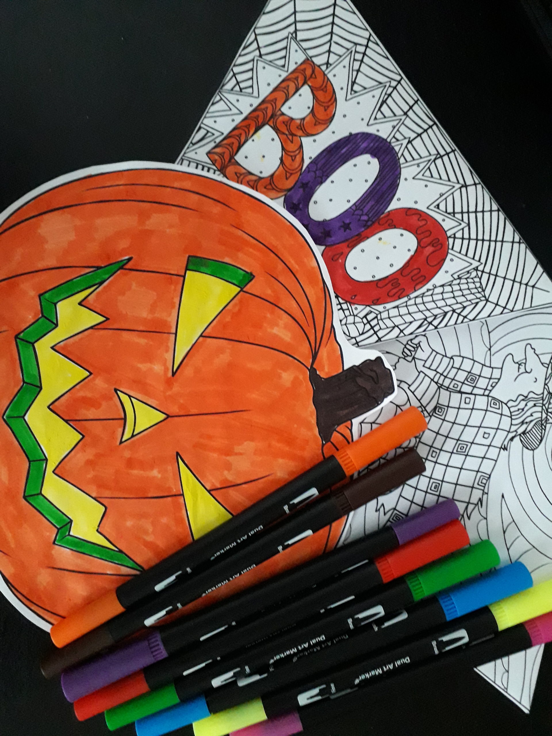 A picture of a pumpkin, a colouring-in sheet and some coloured felt-tip pens.
