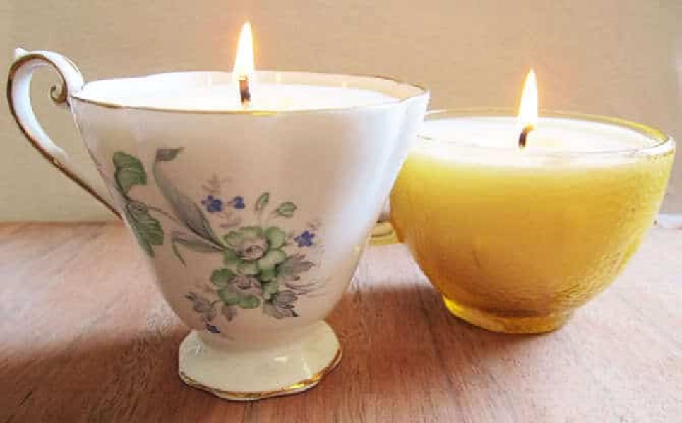 Two teacup candles burn.