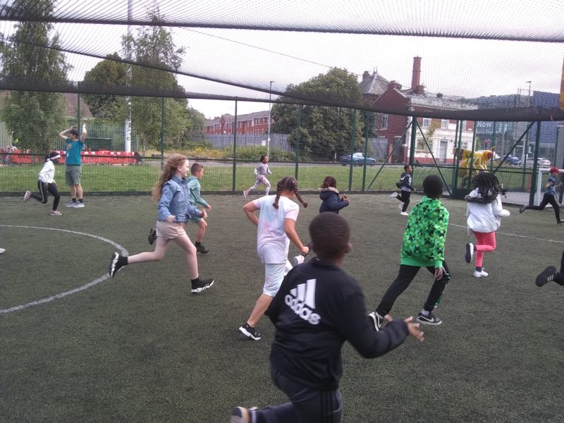 A group of young people play sports outside