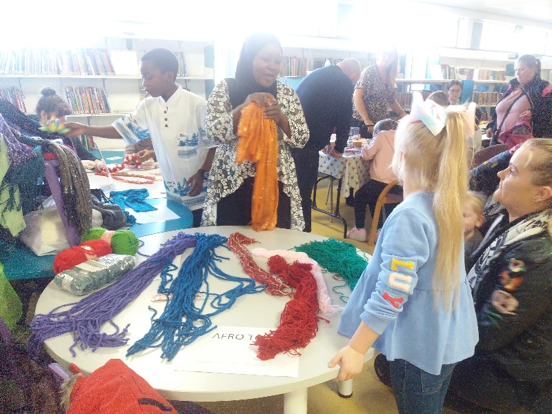 A group of young people take part in a craft session to make African dancing belts.