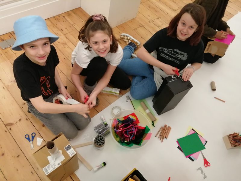 Three young people creating at a crafting table