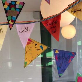 Brightly coloured bunting hangs from the ceiling for International Mother Language Day.