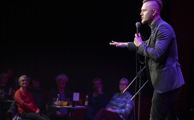 A stand-up comedian performs on stage