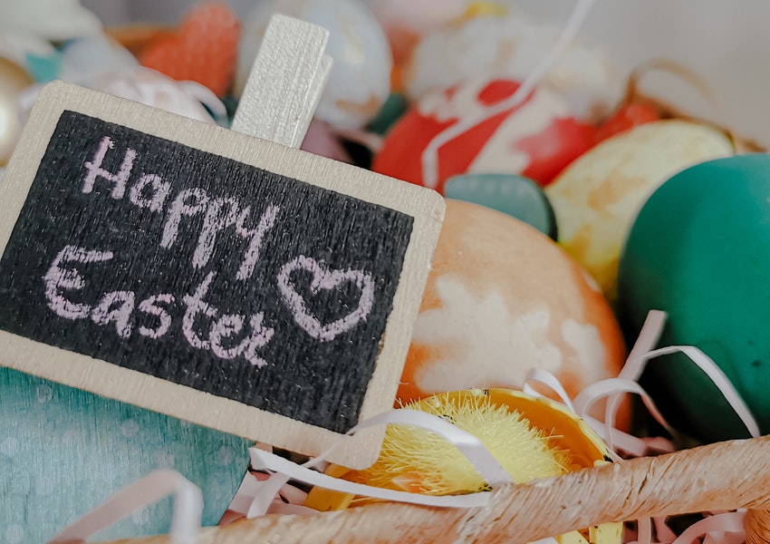 An Easter basket with a chalkboard that reads "Happy Easter".
