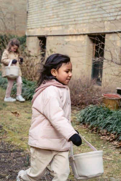 A small child carries a bag on an egg hunt