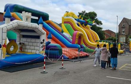 A family stand outside with some bouncy castles