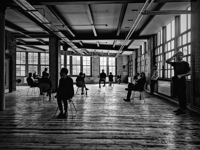 People sat on chairs in a large open space inside a building