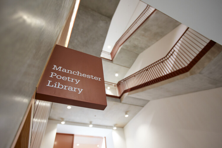 Photo of the sign outside Manchester Poetry Library with stairs in the background
