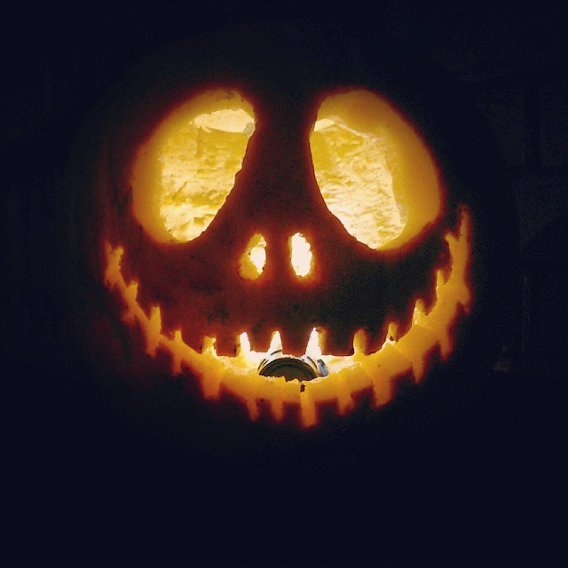 A carved pumpkin with a tealight inside it.