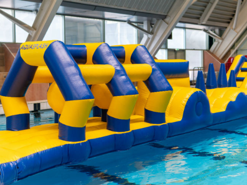 A large blue and yellow inflatable sitting on top of a swimming pool.