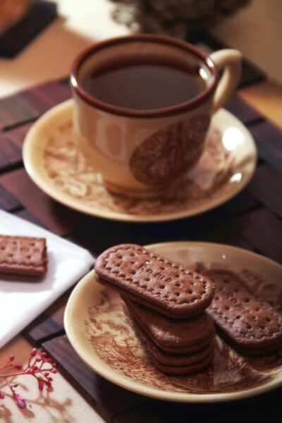 A cup of coffee and some biscuits on a plate.