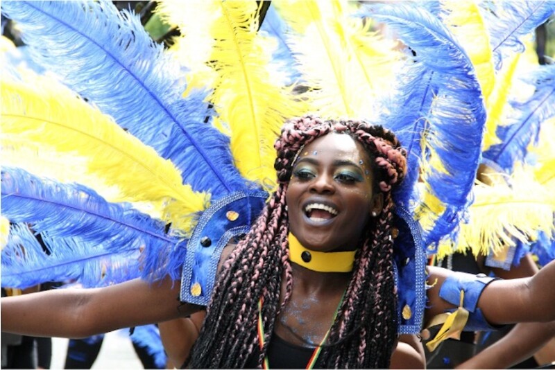 A carnival performer wearing blue and yellow feathers.