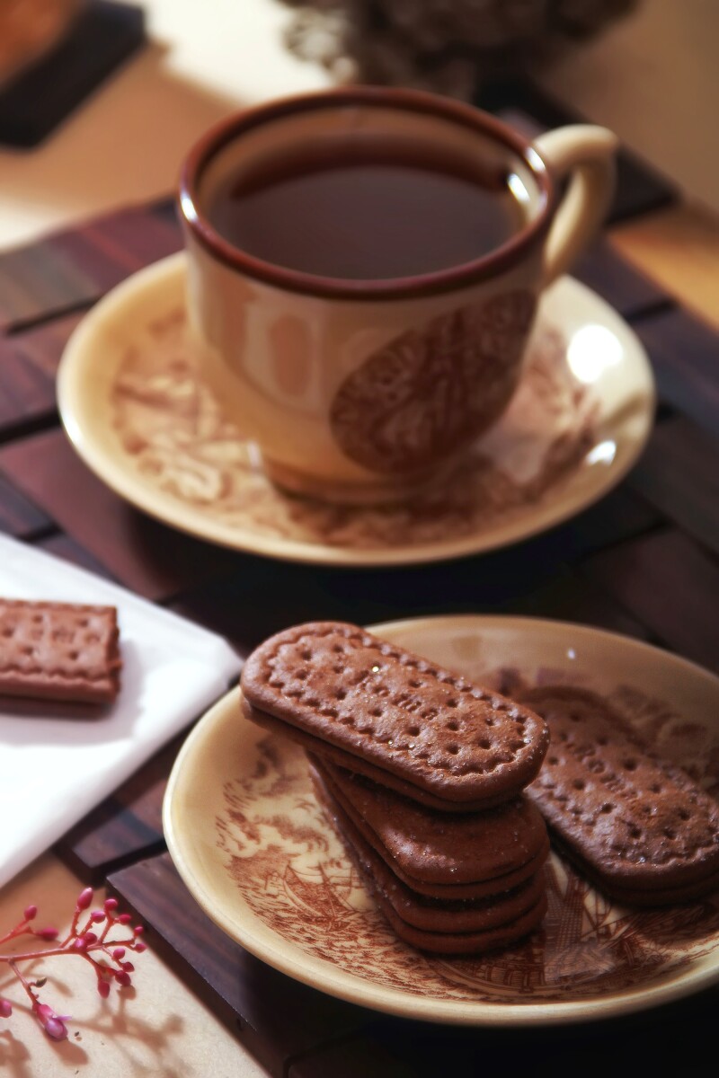 A cup of tea and a plate of biscuits.