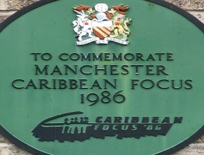 A green plaque that reads 'to commemorate Manchester Carribean Focus 1986".