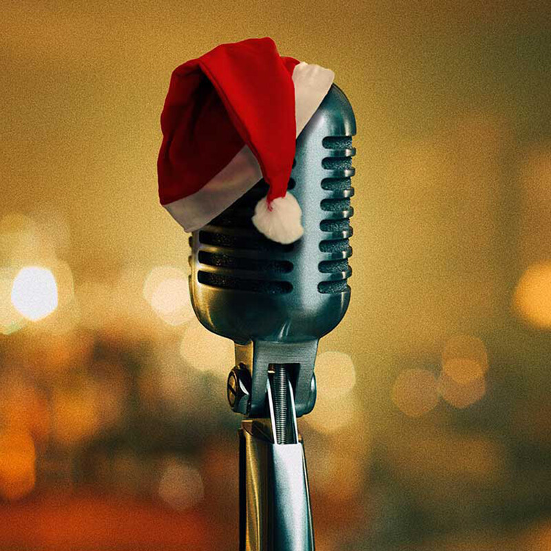 An old style microphone with a Santa hat on it