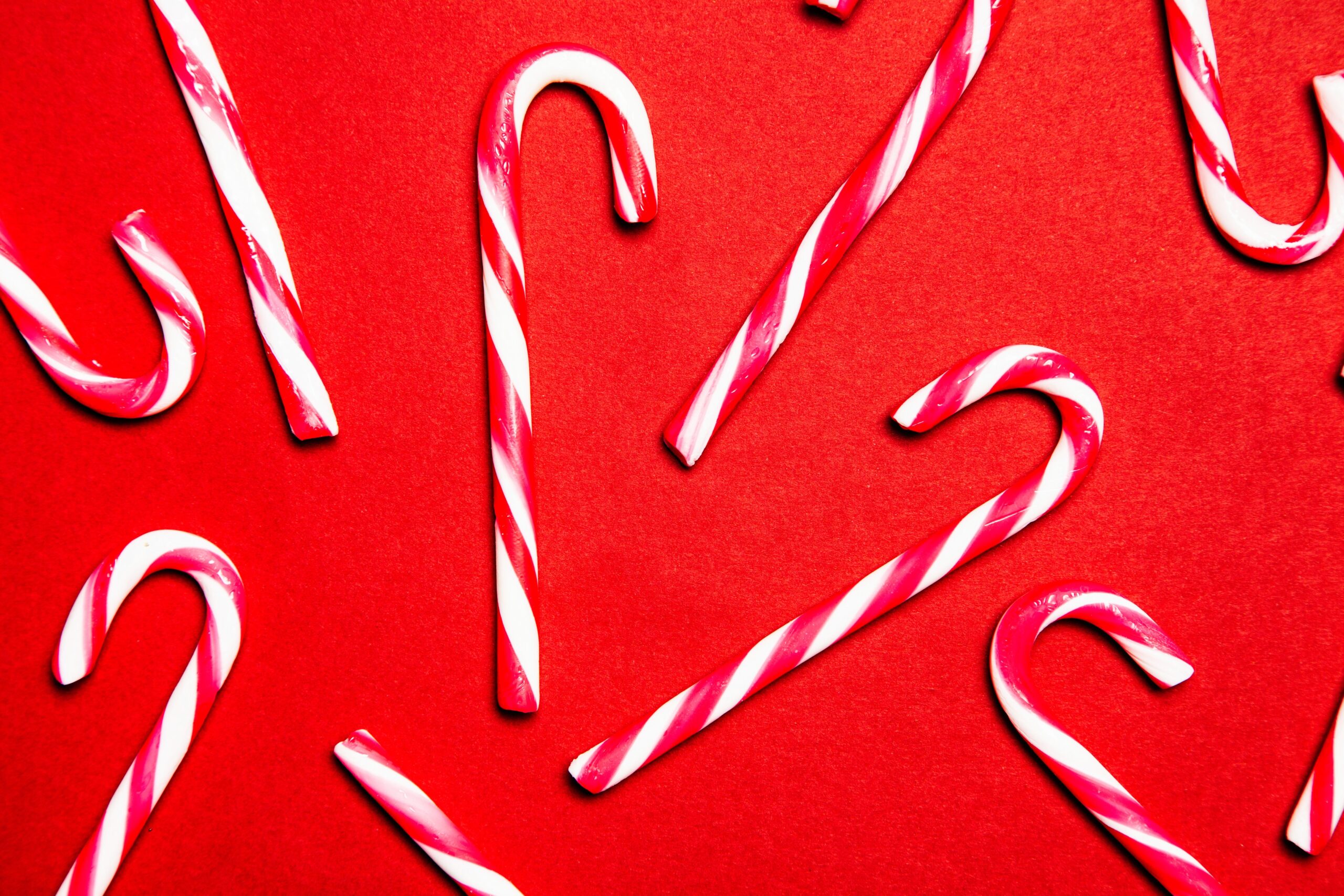 Red and white candy canes on a red background