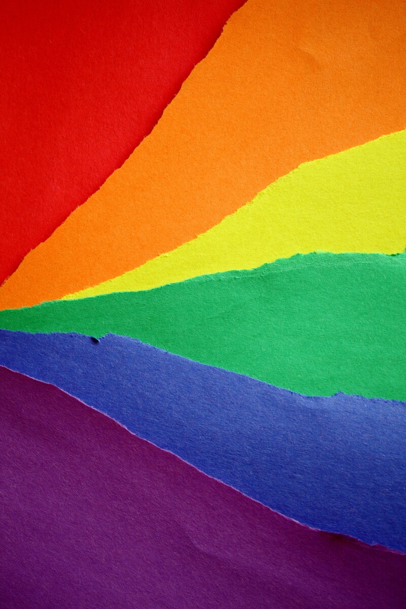 Torn tissue paper in different colours placed next to eachother to create a rainbow.