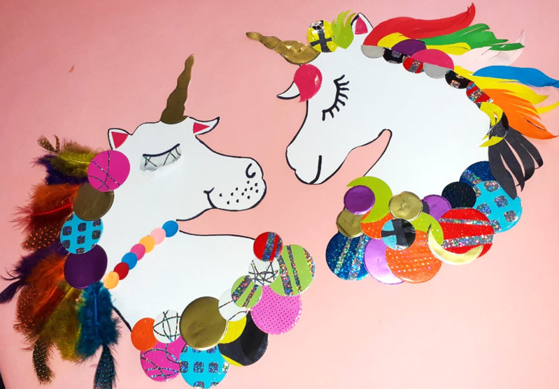Two unicorn heads crafted from brightly coloured paper and card