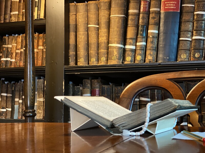 An old book on a book stand on a table in a library