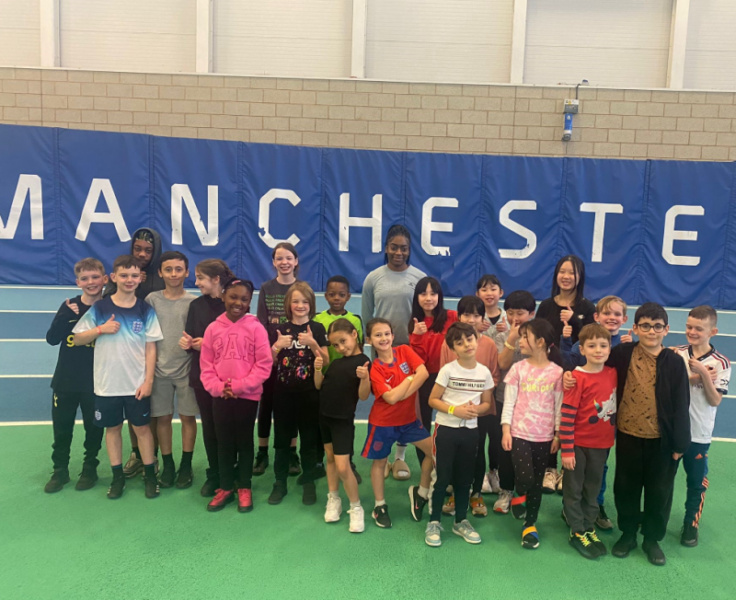 A group of young people stood on Manchester Indoor Athletics Track.