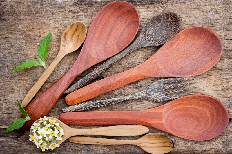 Eight different wooden spoons of all different shapes, colours and sizes.
