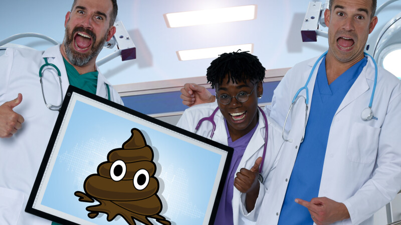 Dr Chris, Dr Xand and Dr Ronx holding a framed cartoon picture of a poo