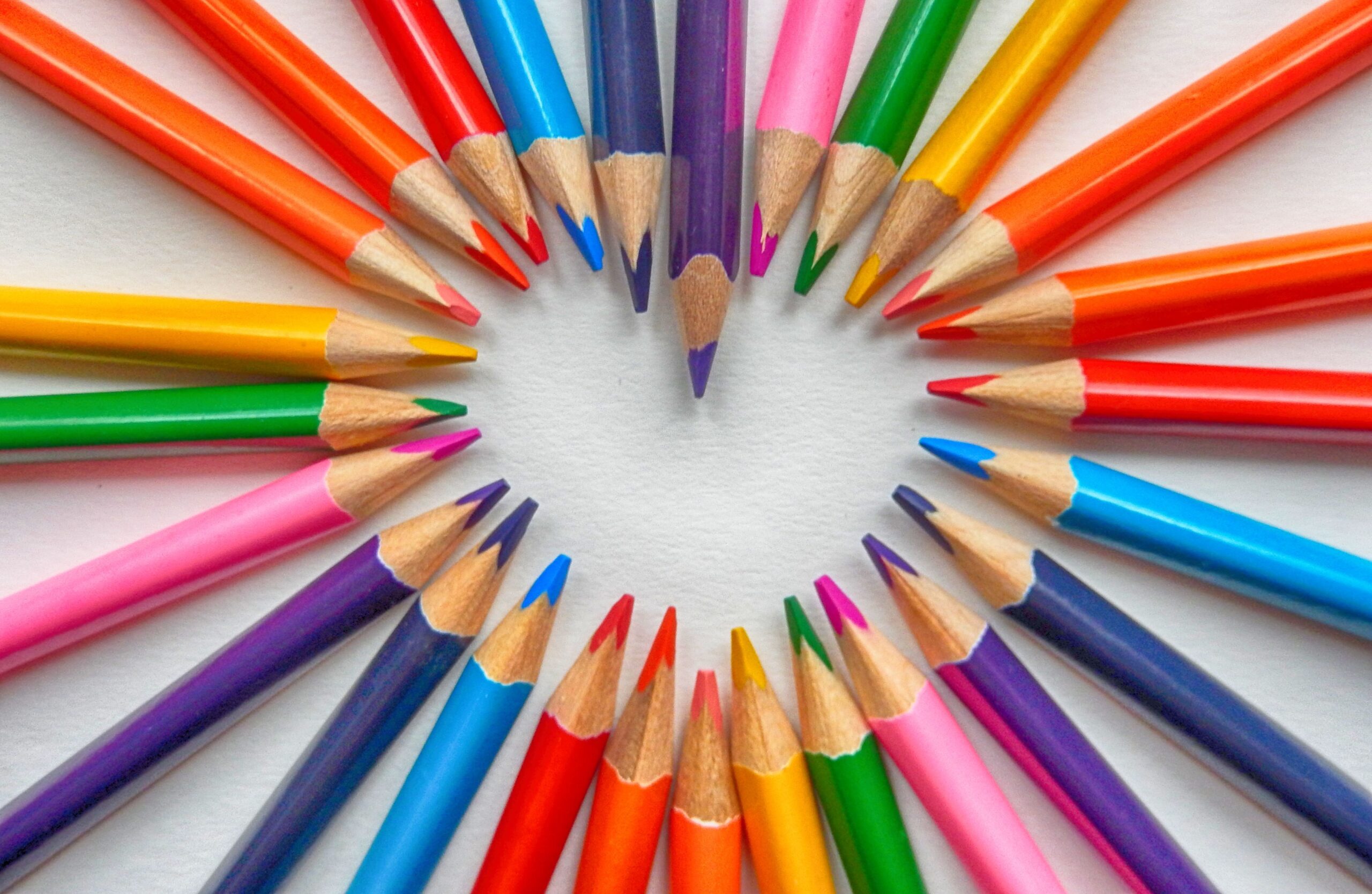 A set of different coloured pencils arranged to form a heart.