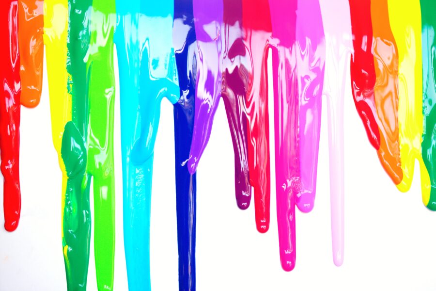 Different coloured paint dripping down a canvas